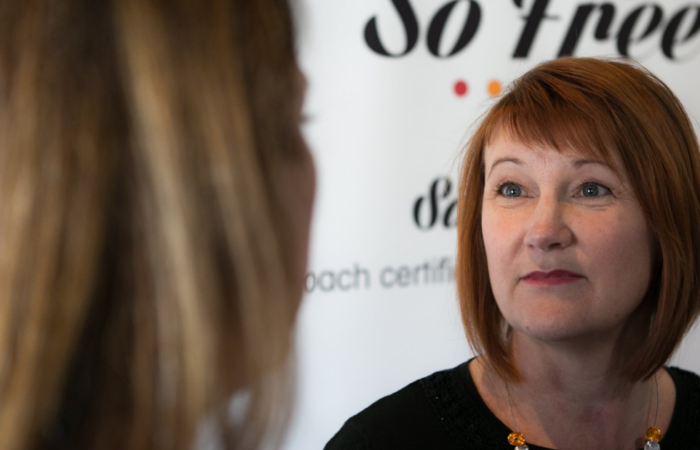 Woman with bob haircut looking at another woman listening
